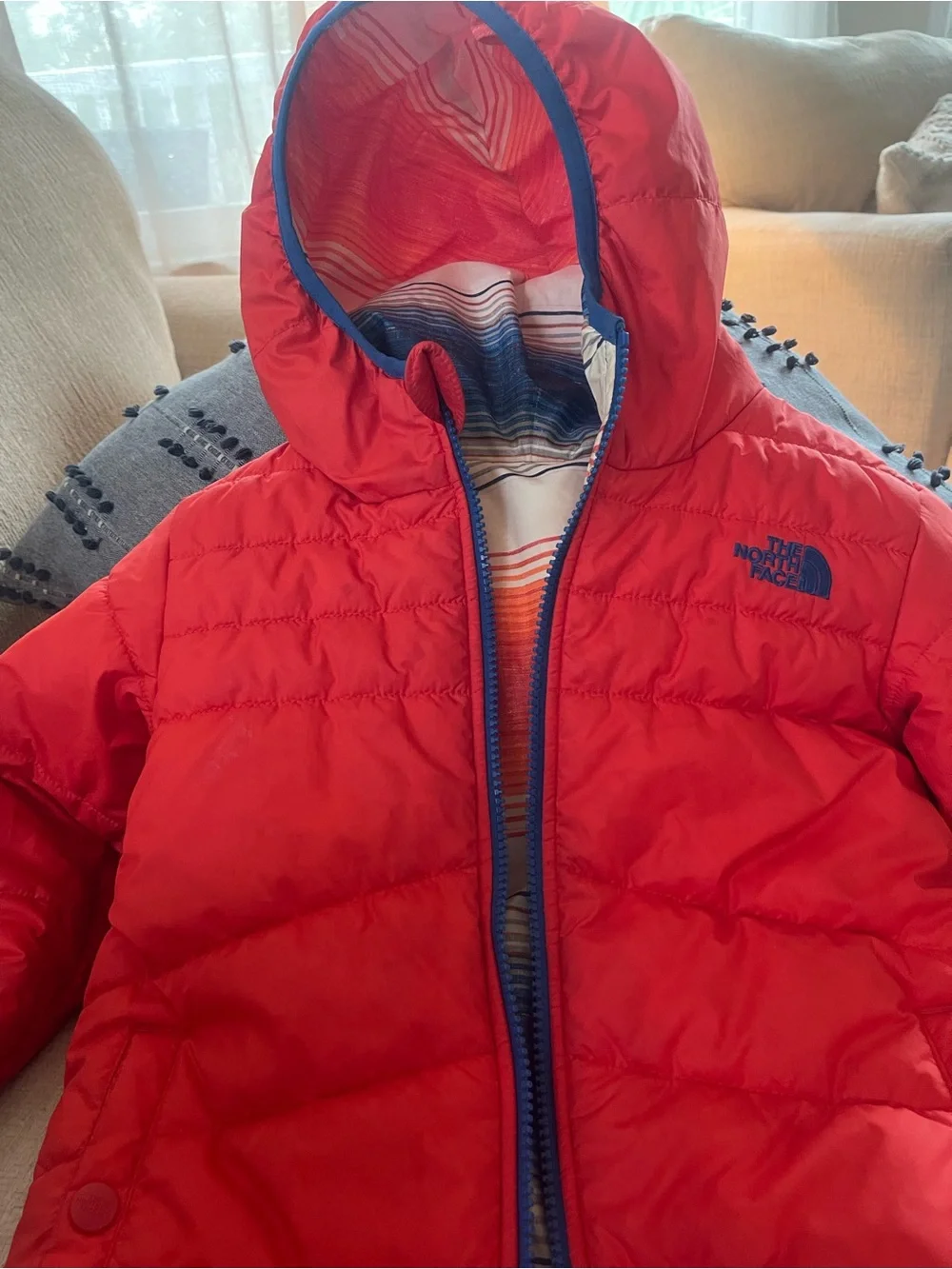The North Face reversible Solid Red or Vibrant Striped side Puffer Jacket.